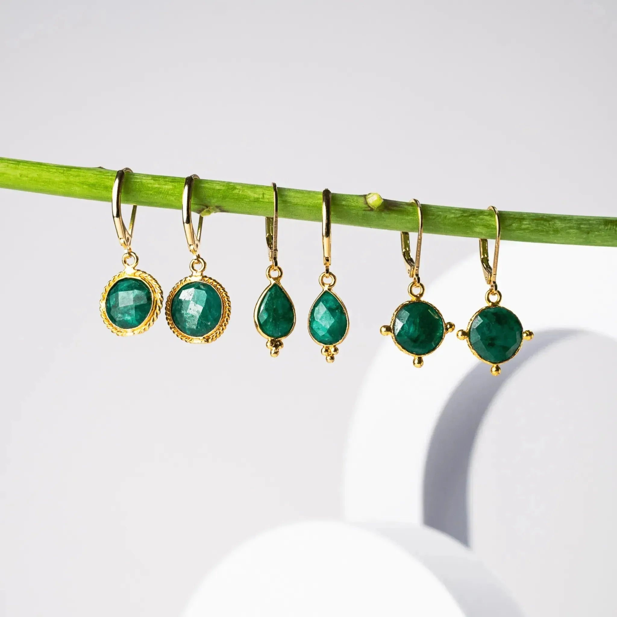 BLOG emerald green earrings hanging from a branch