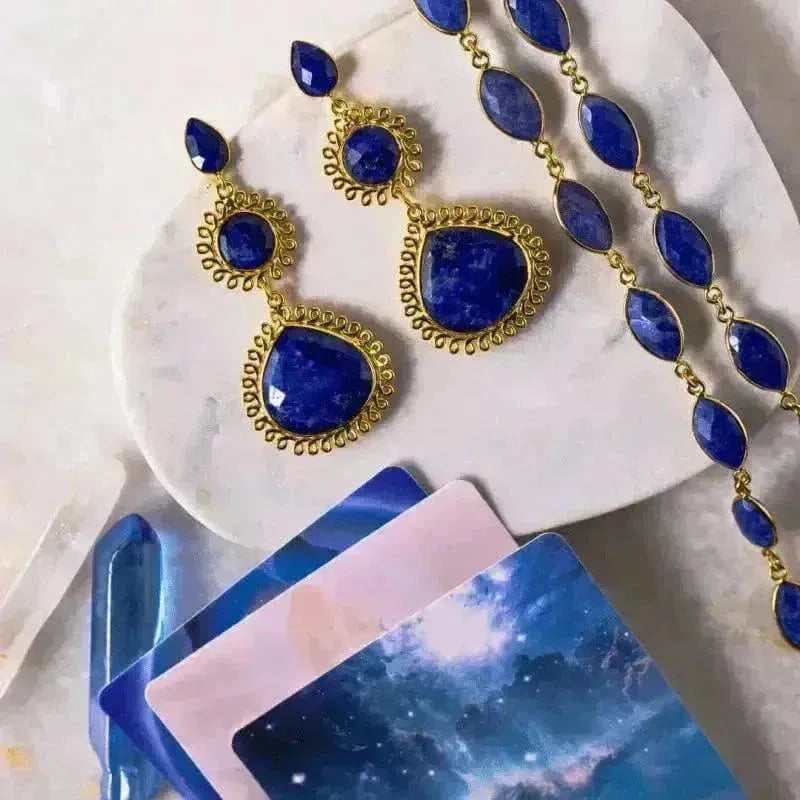Gold sapphire gemstone chain necklace and matching earrings on a white background — September birthstone jewelry