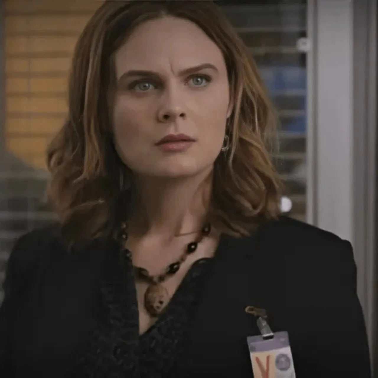 emily daschenel dr brennace bones wearing a black outfit with a name tag in an indoor setting