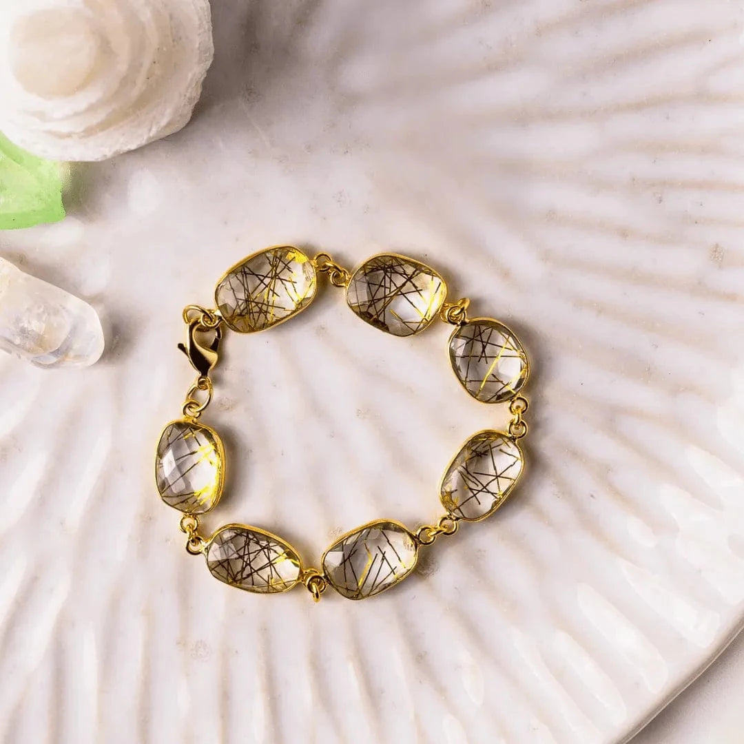 Gold bracelet with gemstones on a shell background