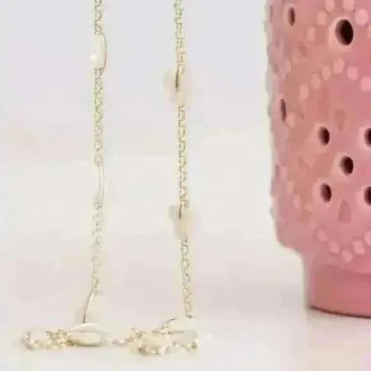 Gold necklace with a pink ceramic holder on a white background