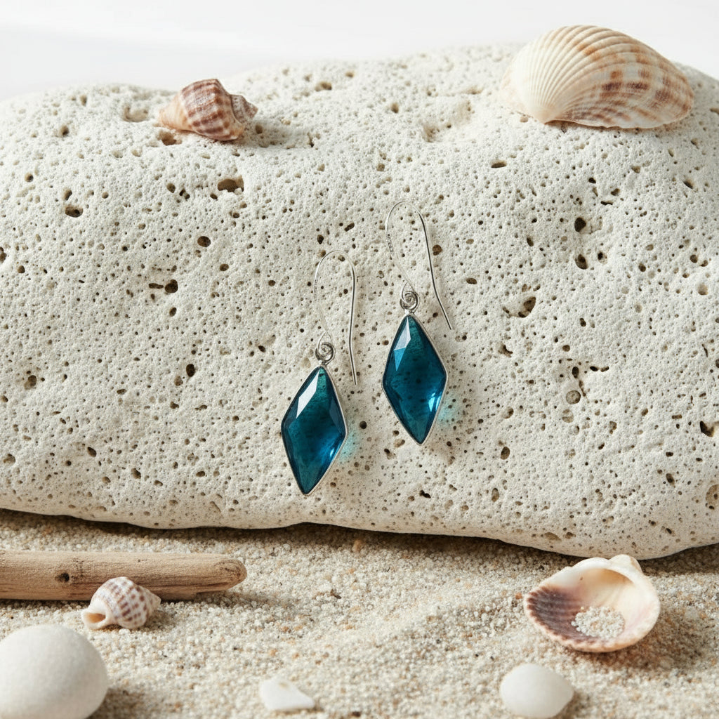 Pair of blue diamond-shaped earrings on a light background