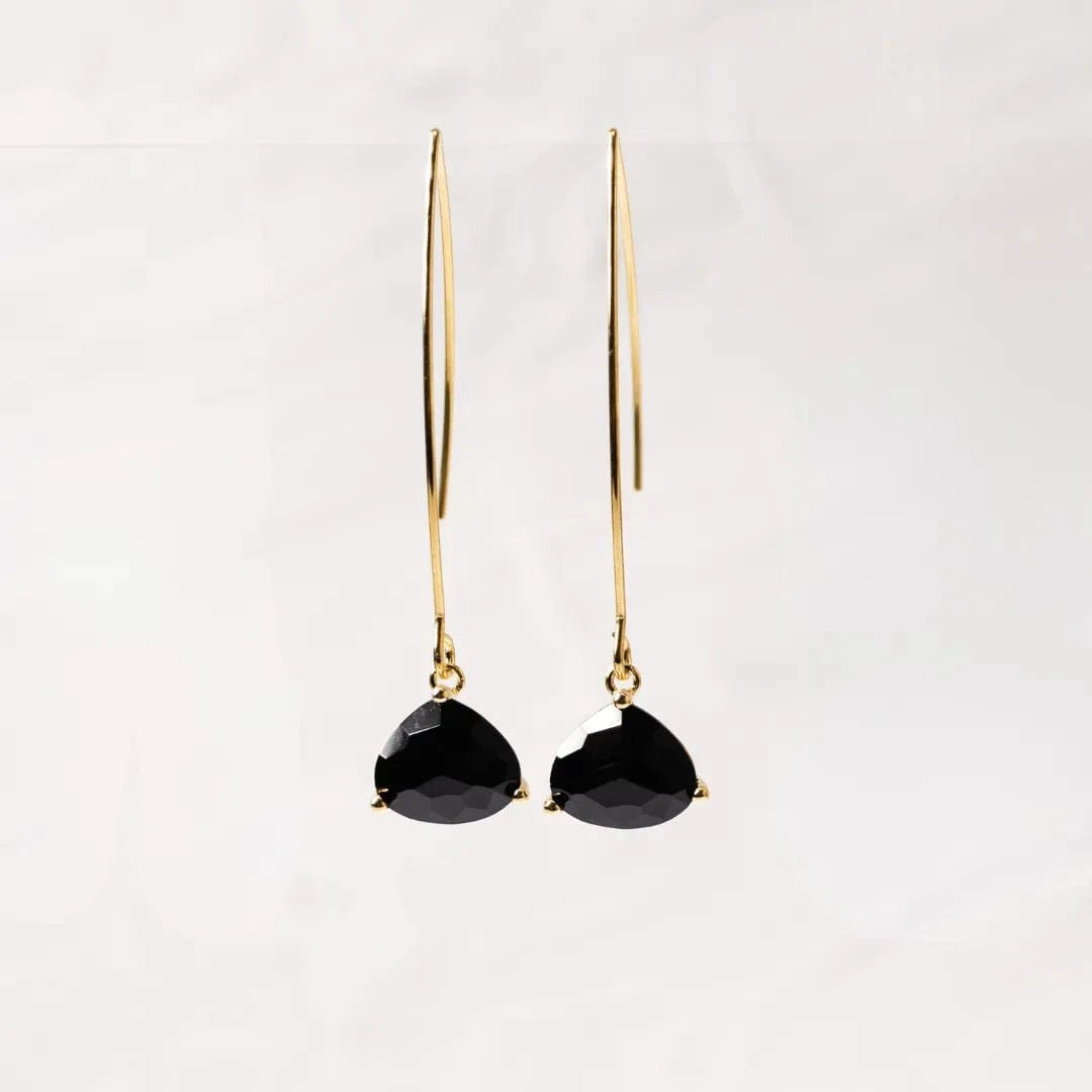 Gold earrings with black gemstones on a white background