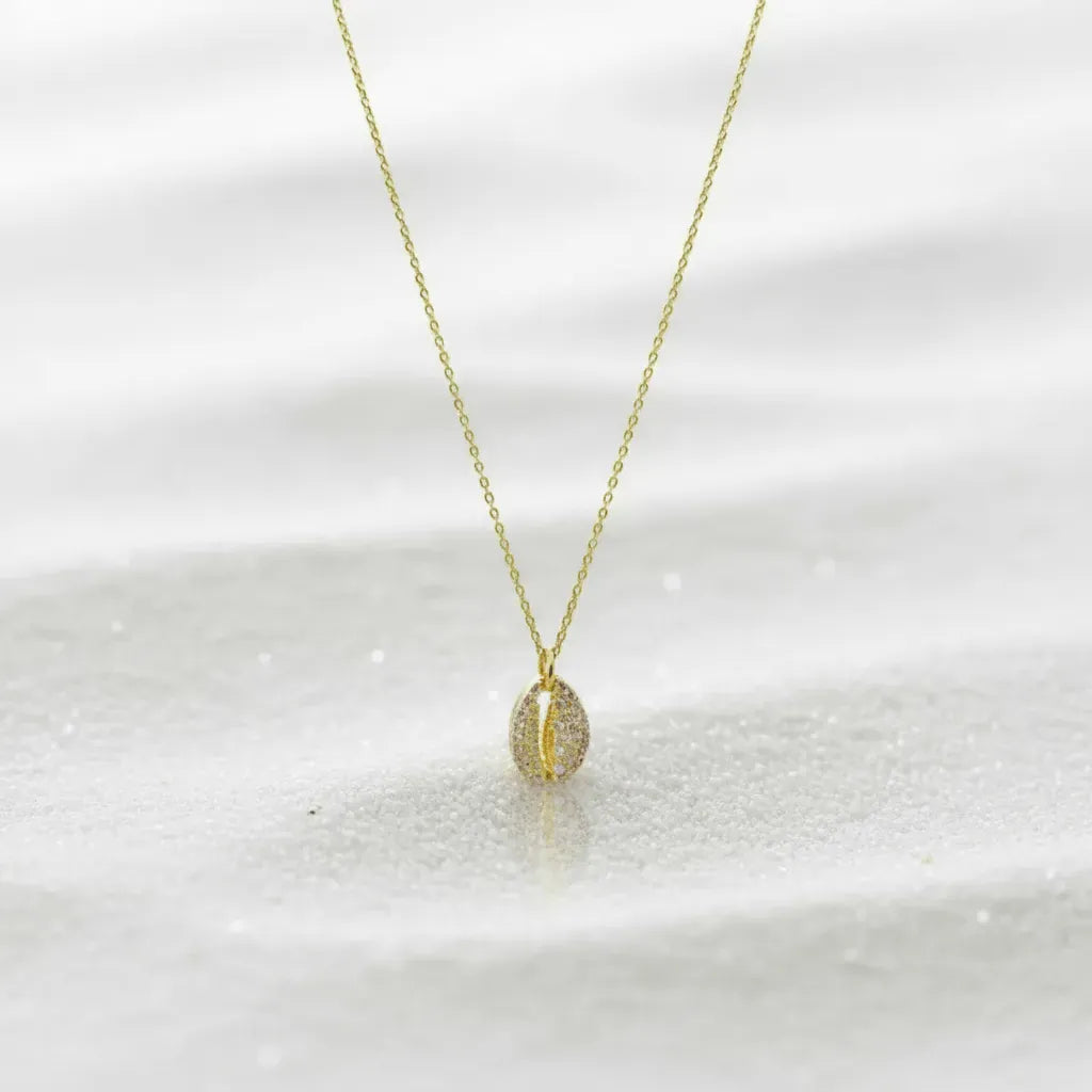 Gold necklace with a small pendant on a white background