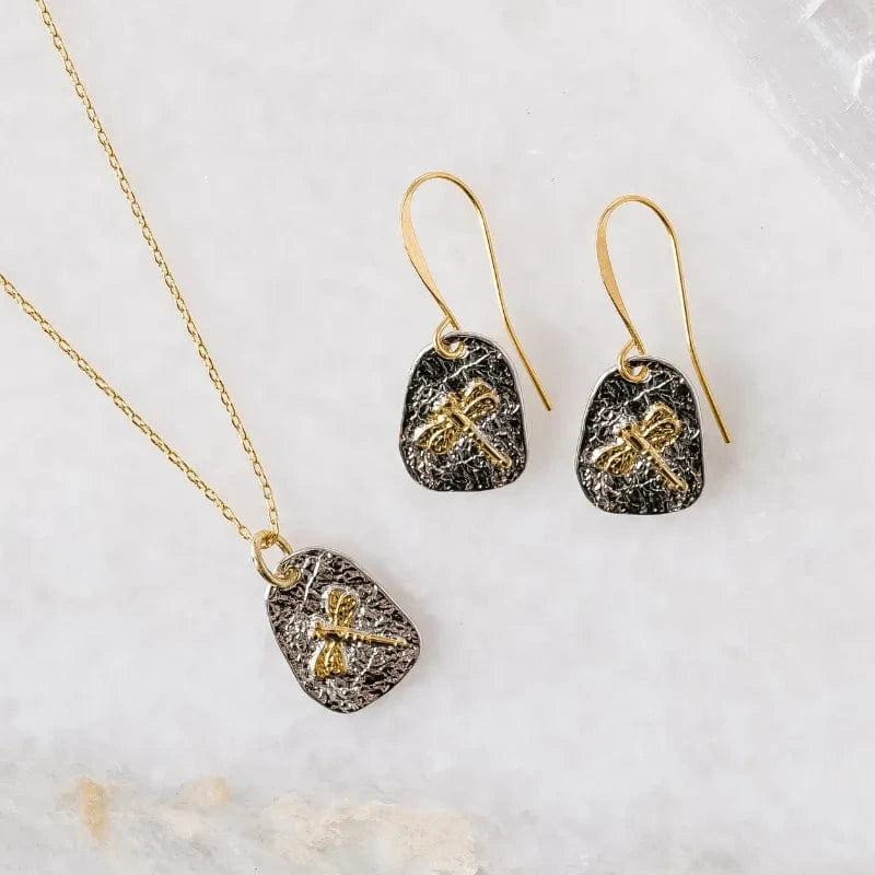 Jewelry set with pendant necklace and earrings on a marble surface