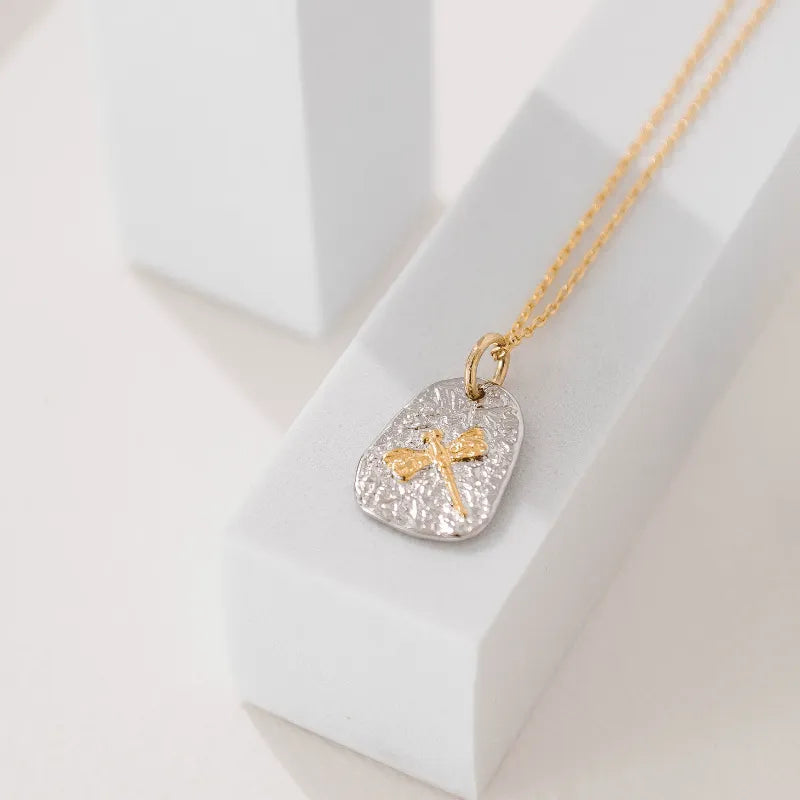 Gold and silver pendant necklace on a white surface