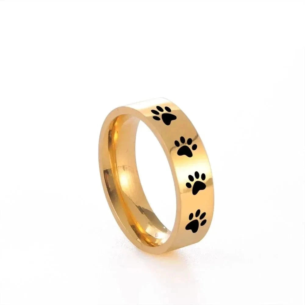 Gold ring with black paw prints on a white background