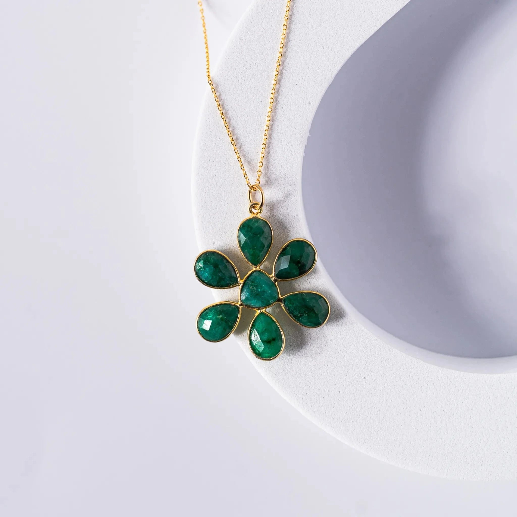 Gold-plated flower pendant necklace featuring an opaque emerald stone