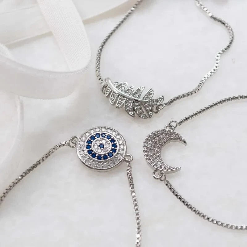 Two silver necklaces with unique pendants on a white surface