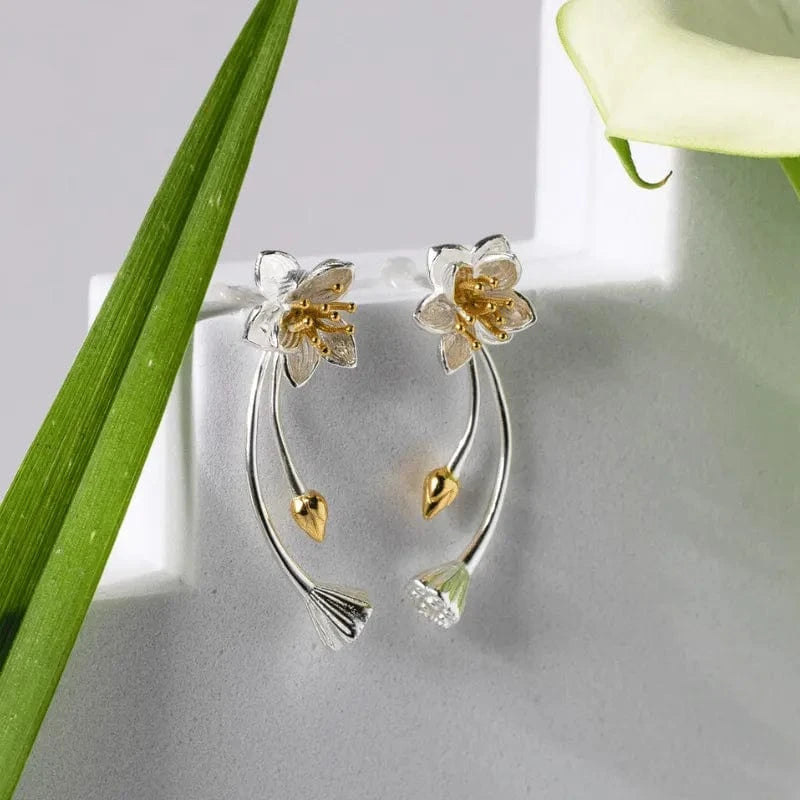 Floral earrings with gold and silver details on a light gray background
