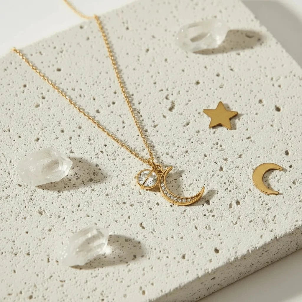 Gold necklace with moon and star pendant on a textured surface
