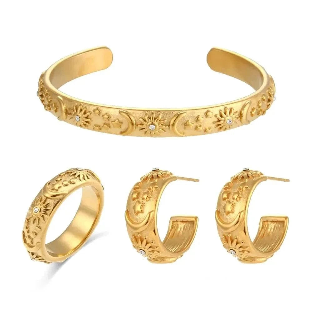 Gold jewelry set including a bracelet and earrings on a white background