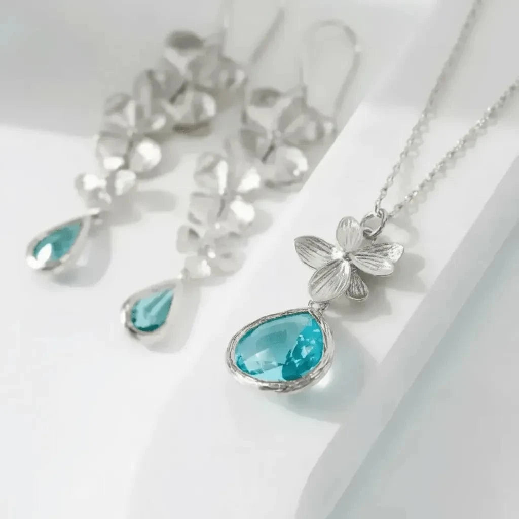 Silver necklace with blue pendant on a white background