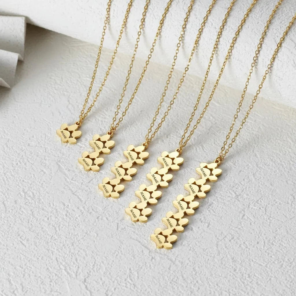 Gold necklaces with floral pendants on a green background