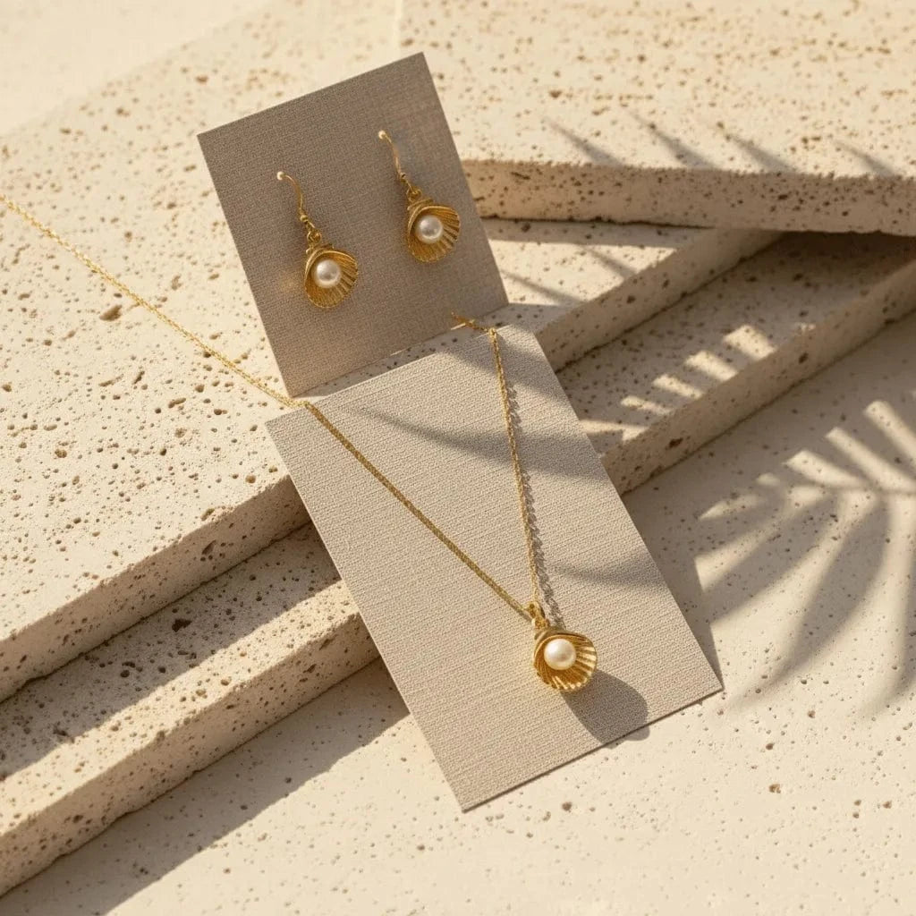 Gold necklace and earrings on beige display cards with a textured surface background
