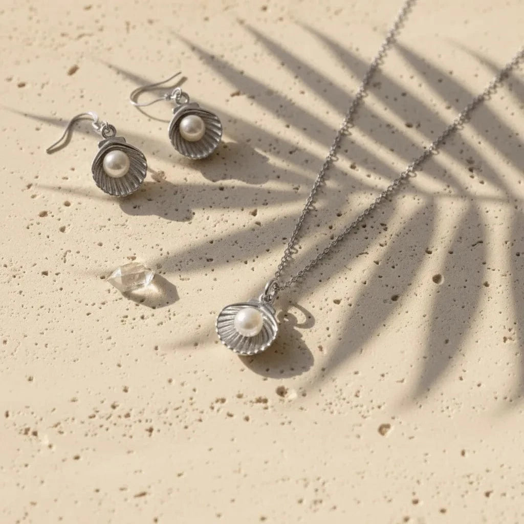 Silver jewelry set with pearls on a beige surface