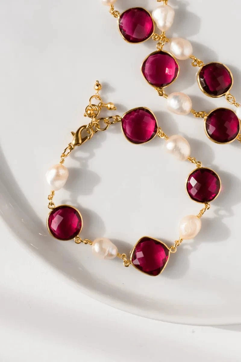 Necklace with red gemstones and pearls on a white background