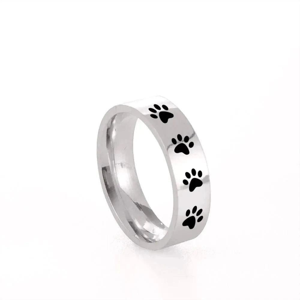 Silver ring with black paw prints on a white background