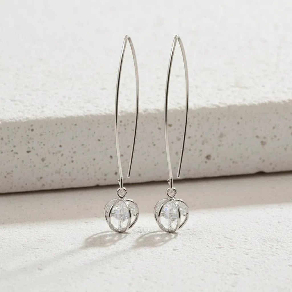 Silver hoop earrings with circular ends on a light background