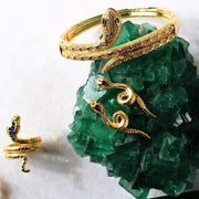 Gold snake-shaped bracelet on a green crystal
