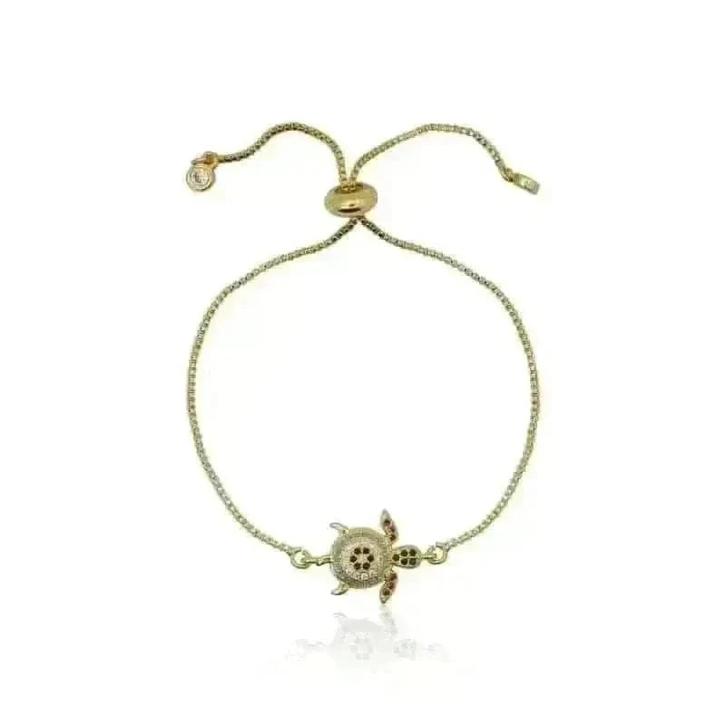 Gold bracelet with a turtle charm on a white background