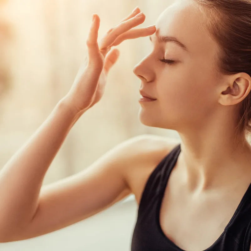 woman holding hand to third eye