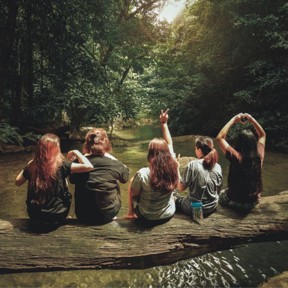 Women sitting on a log over water in nature — self-worth rituals for women, small daily practices