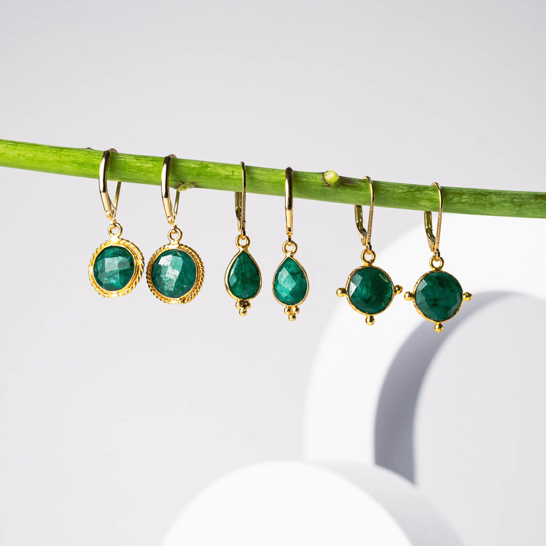 BLOG emerald green earrings hanging from a branch 