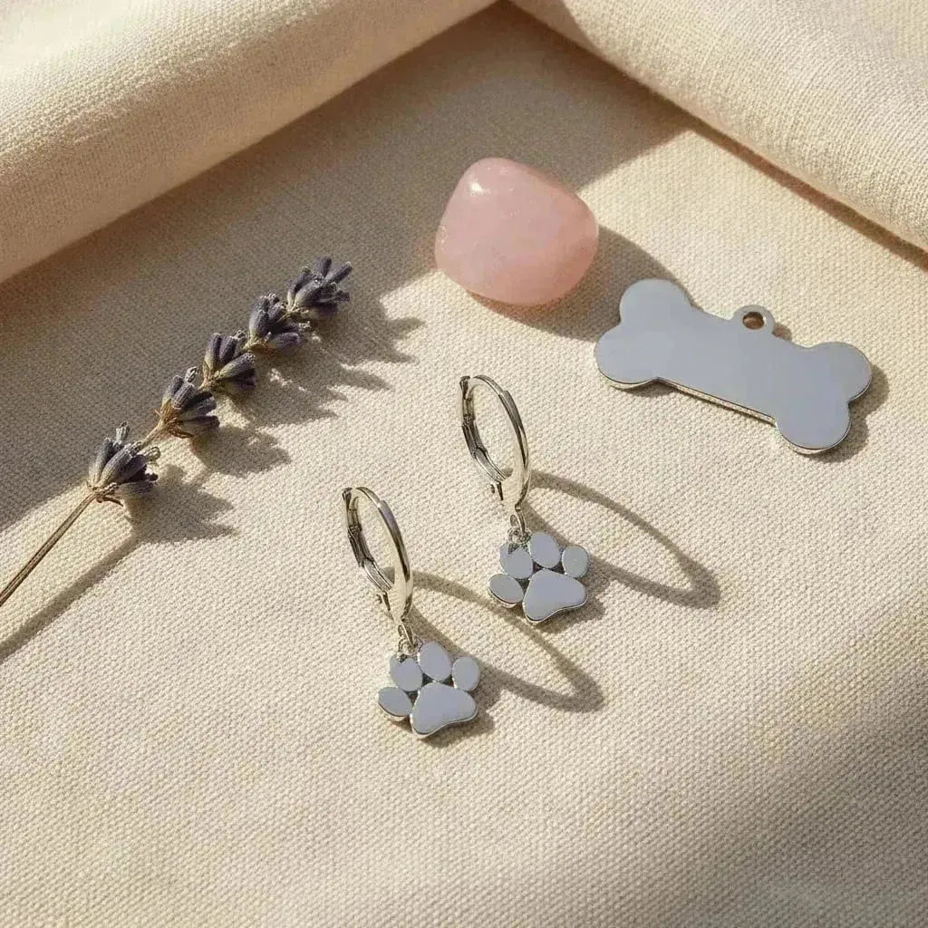 silver paw earrings on light background with dog bone dog tag and rose quartz