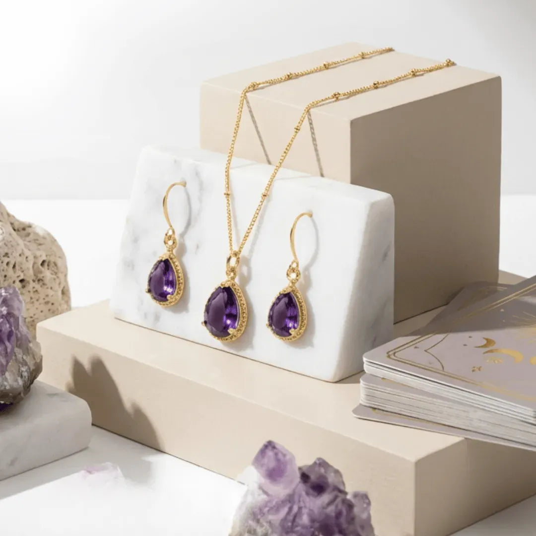 purple and gold necklace earrings on a light background