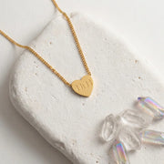 Gold 111 angel number necklace with a heart-shaped pendant on a white 