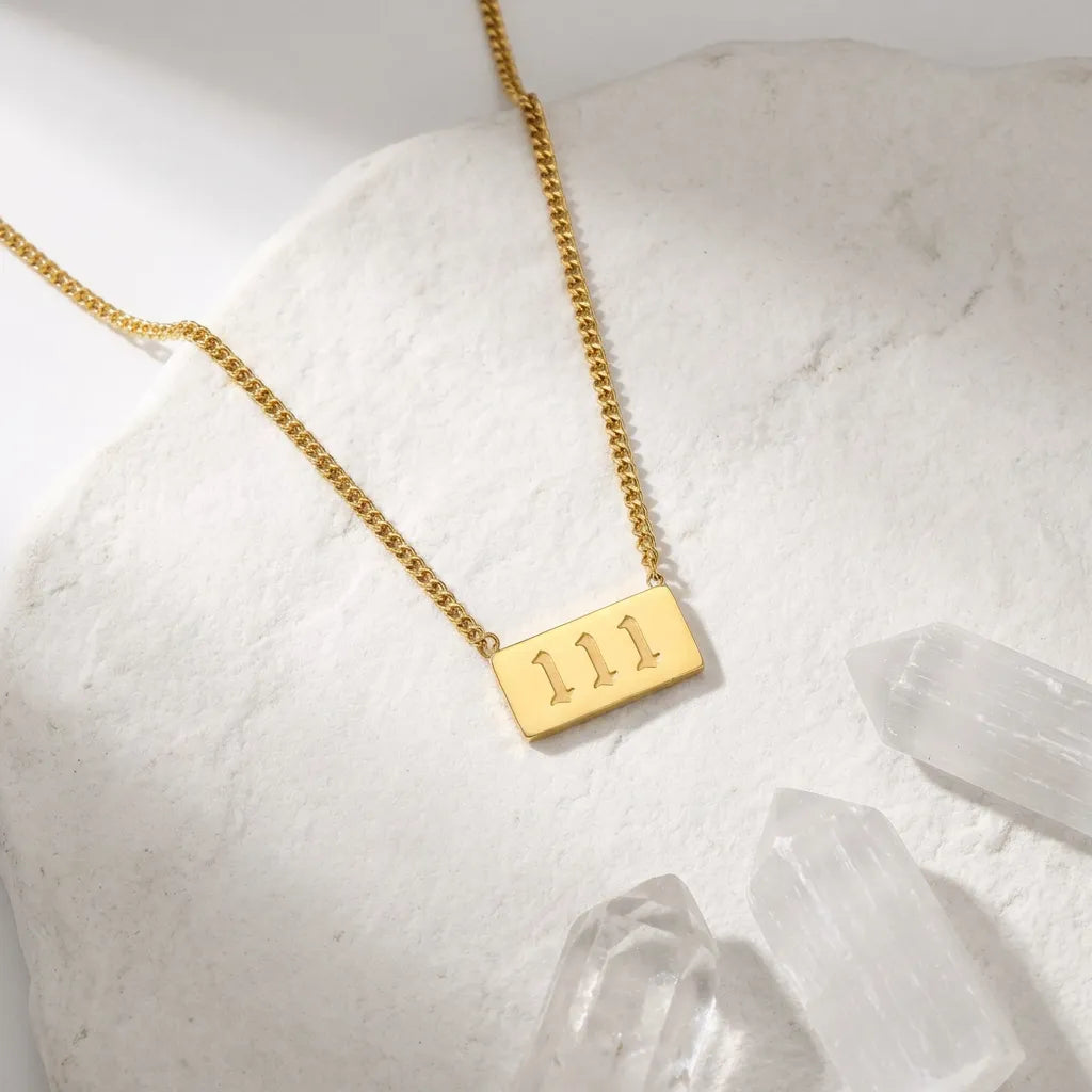 111 gold angel number rectangle pendant necklace with crystals on a light background