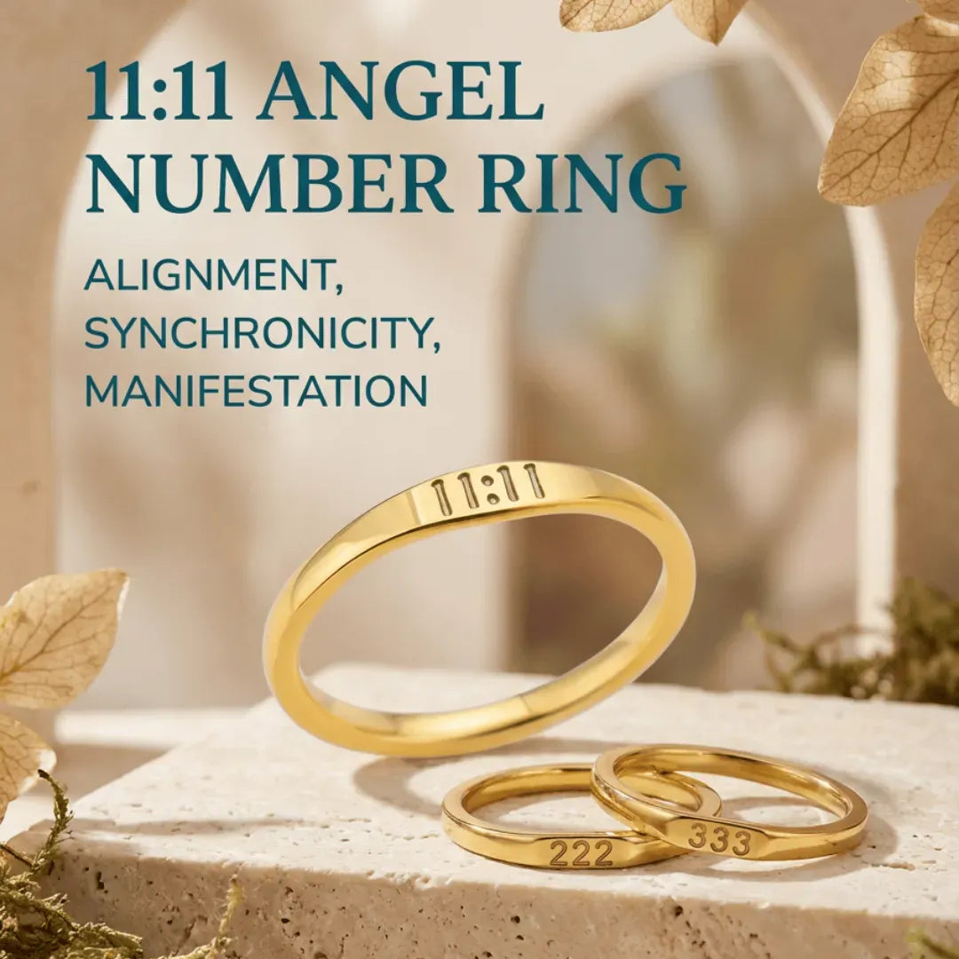 Gold rings with numbers on a stone surface with leaves, promoting '11:11 Angel Number Ring'.
