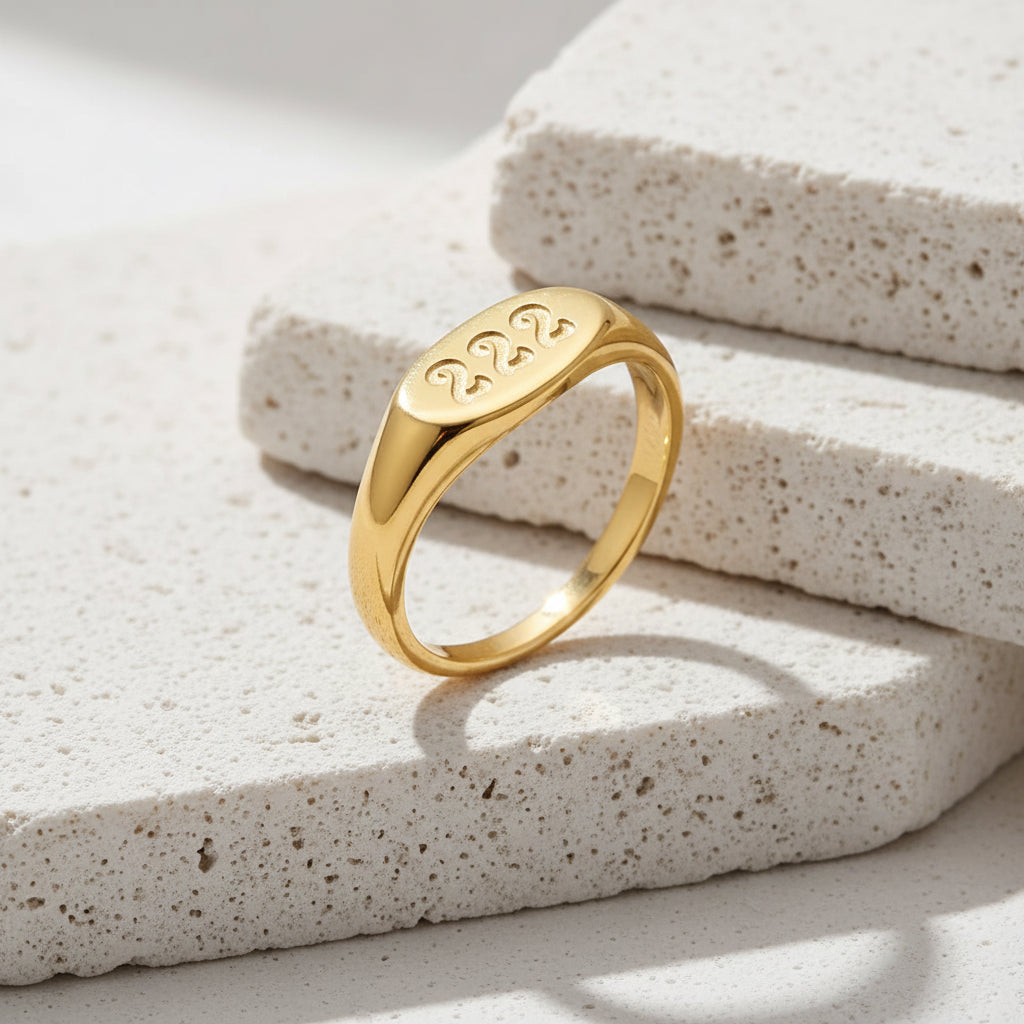 Gold ring with '222' engraving on a white background