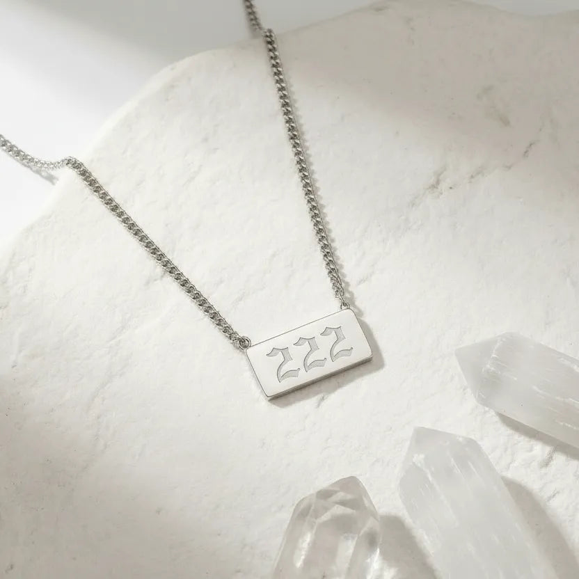 222 gold angel number rectangle pendant necklace with crystals on a light background