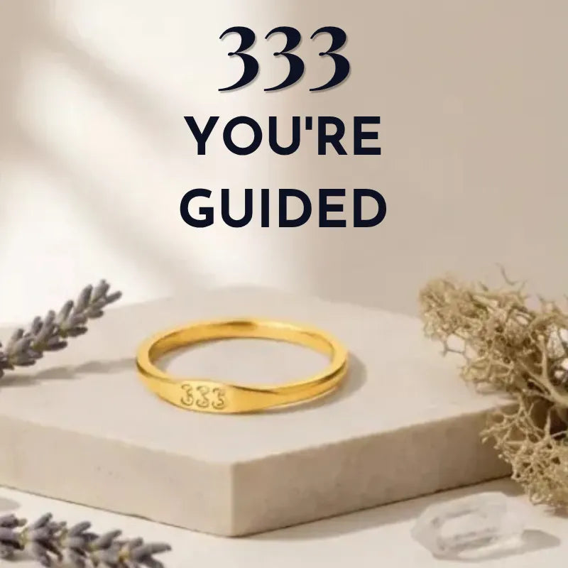 Gold bracelet with '333' engraving on a neutral background with text '333 YOU'RE GUIDED'.