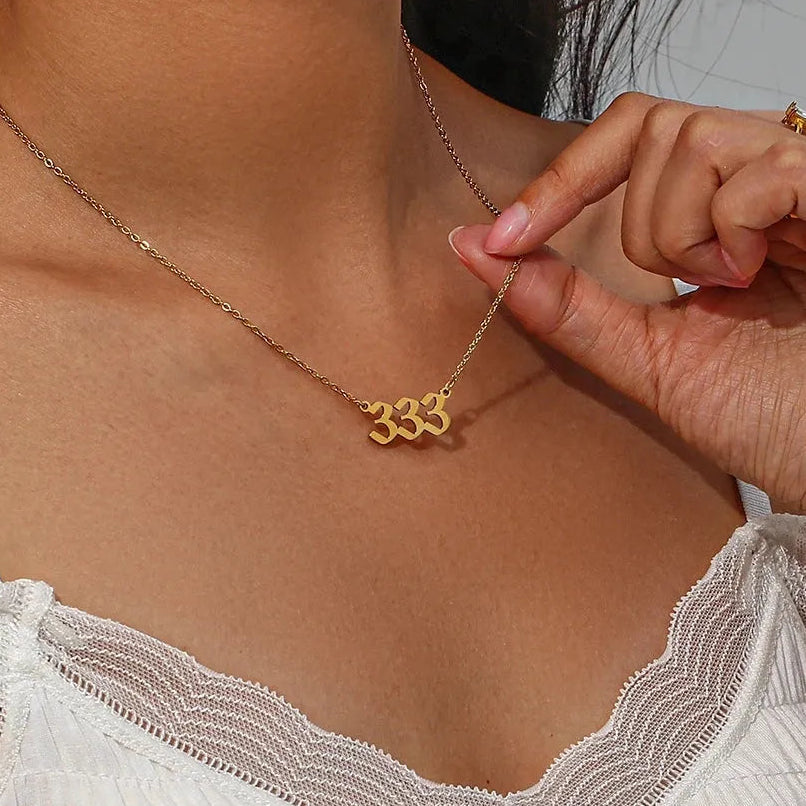 woman wearing gold 333 angel number pendant necklace — spiritual symbol jewelry for alignment