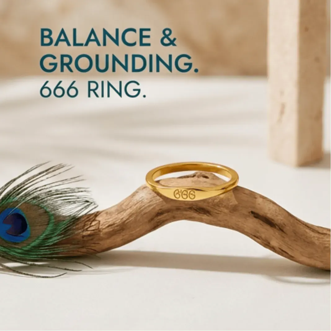 Gold ring with '666' engraving on a wooden branch with a peacock feather, text 'BALANCE & GROUNDING. 666 RING.'