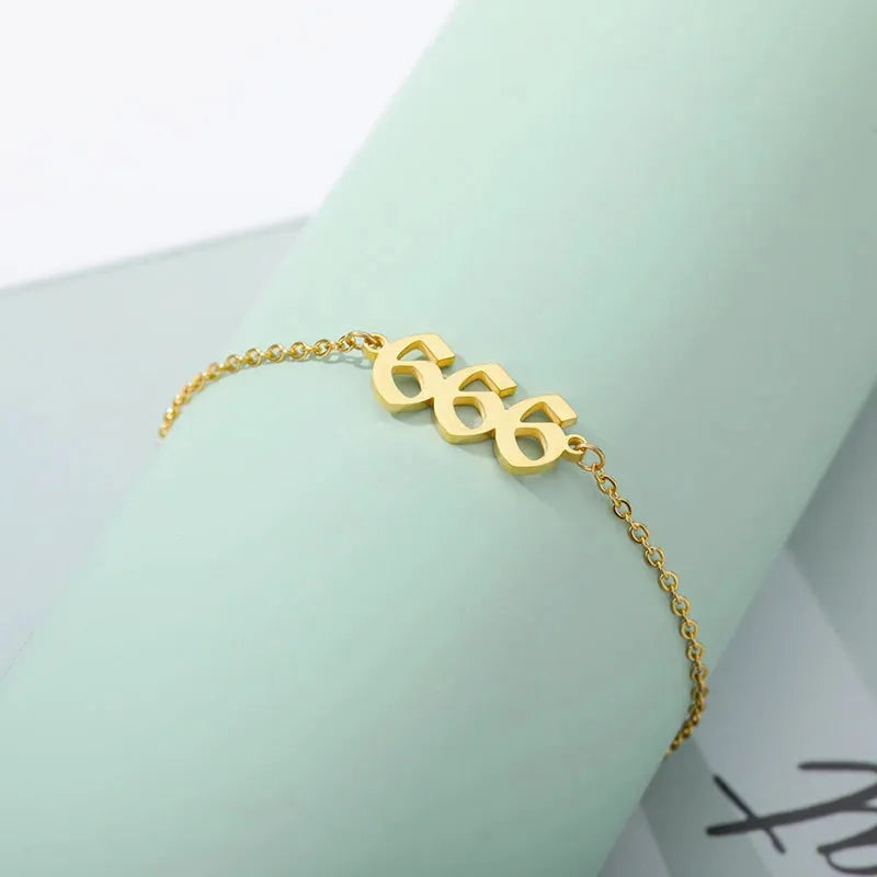 Gold bracelet with a unique design on a light green background 666