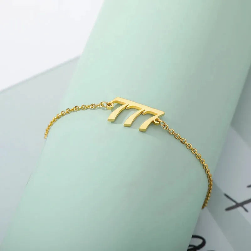 Gold bracelet with a unique design on a light green background
