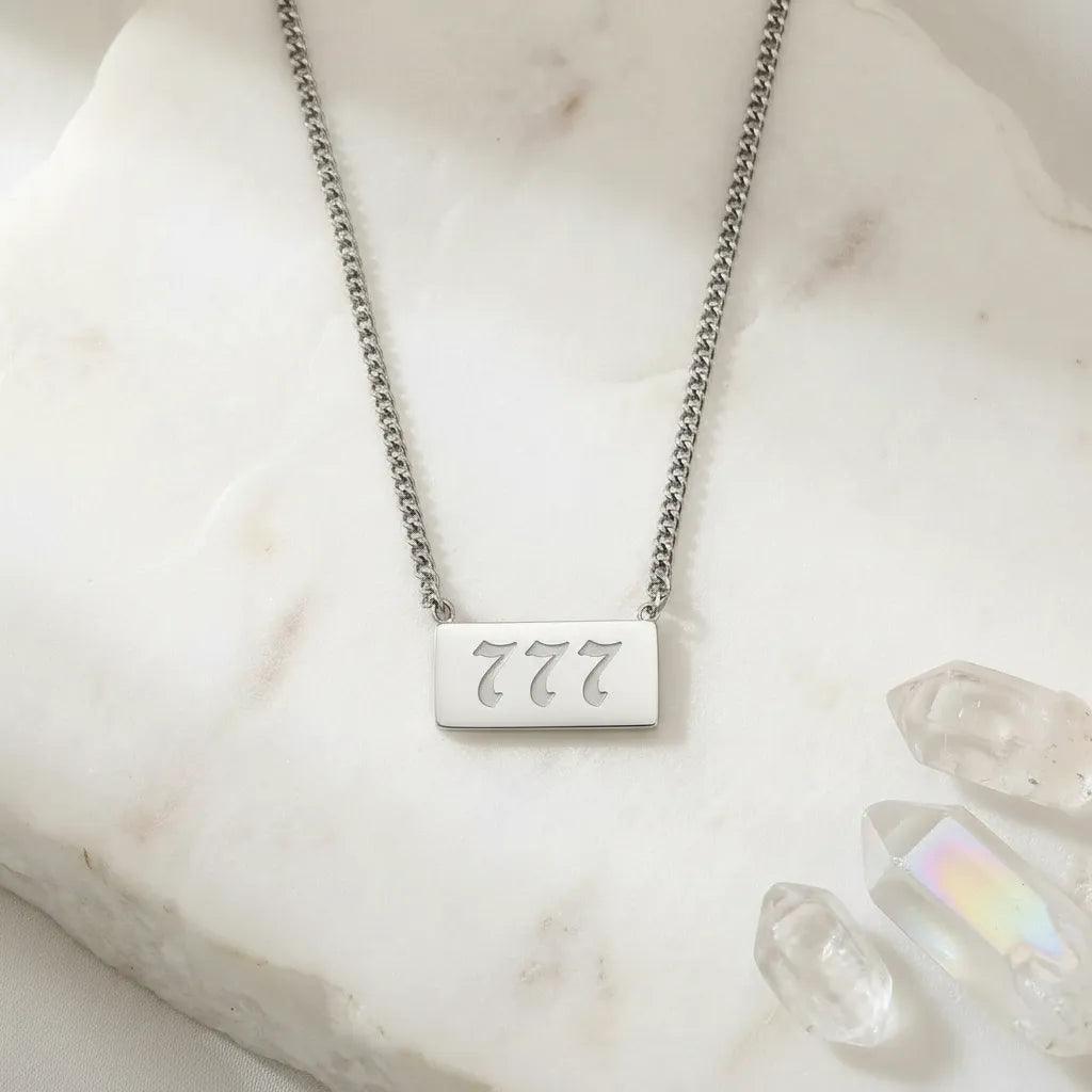 777 angel number rectangle pendant necklace with crystals on a light background