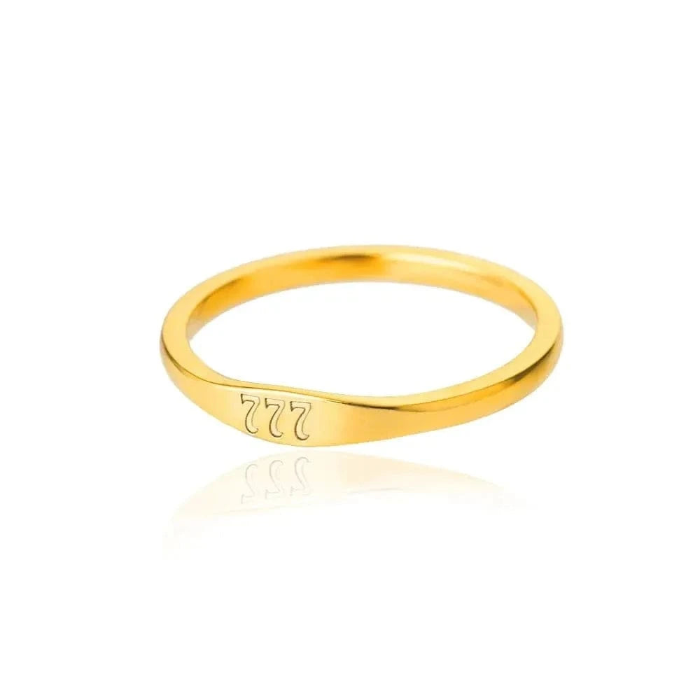 Gold ring with engraved design on a white background