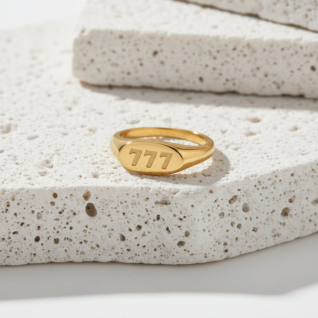 Gold ring with 777 text on a white background