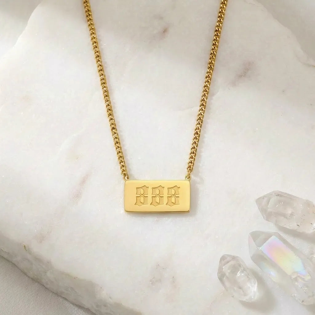 888 gold angel number rectangle pendant necklace with crystals on a light background