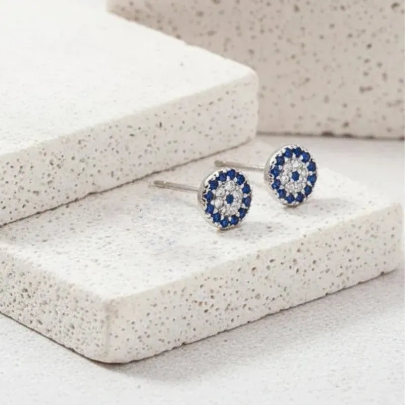 Pair of blue and silver earrings on a textured white surface