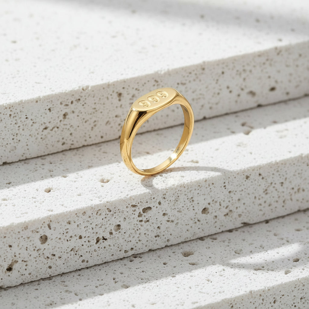 Gold ring with '999' engraving on a white background