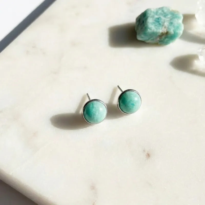 Turquoise stone stud earrings on a marble surface