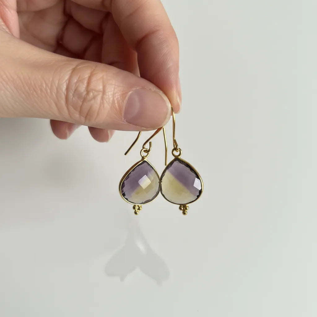 gold ametrine drop earrings held in hand — crystal jewelry for balance and clarity