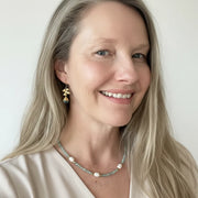 Woman wearing an aquamarine and potato pearl necklace with blue topaz orchid drop earrings — one-of-a-kind ocean set