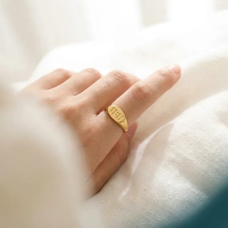 Gold ring on a finger against a soft, blurred background